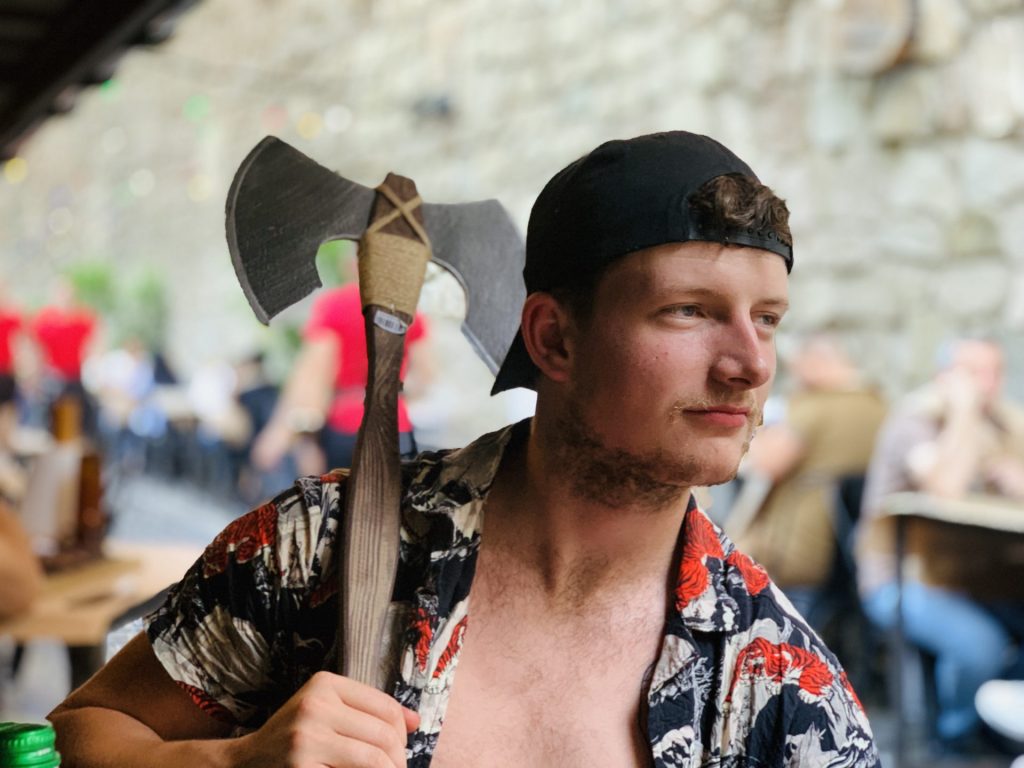 Funny picture of Nathan Mullaney, working with Actions Beyond Words (ABW) after dinner at a themed restaurant in Lviv - wielding as toy axe!