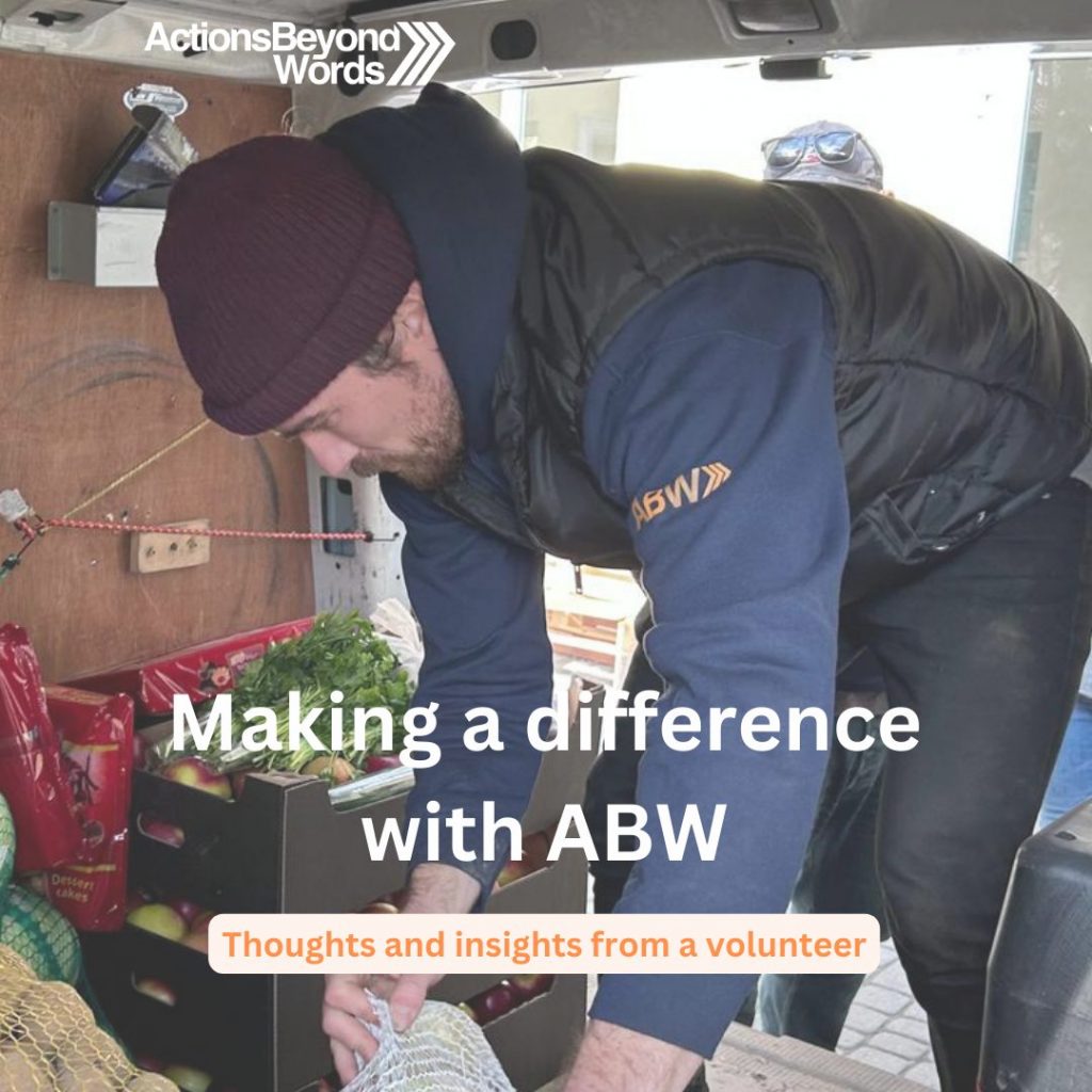 An ABW volunteer bending over in a van to pick up fresh fruits and vegetables.